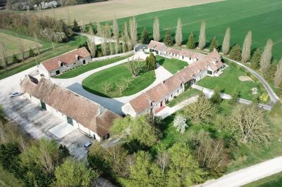Panneau indiquant ’Le Grand Villeboublain’ près d'une route bordée d'arbres dans un paysage rural.