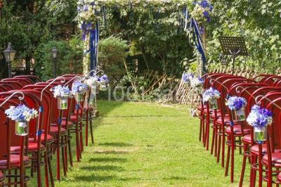 Intérieur d'une yourte avec trois lits en bois sculpté disposés autour d'un espace central sur un sol en bois.