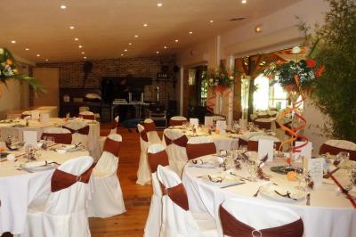 Salle de bain mansardée avec douche en briques de verre, vasques en verre, meubles en bois et fenêtre de toit.