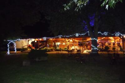 Salle de bain mansardée avec douche en briques de verre, vasques en verre, meubles en bois et fenêtre de toit.