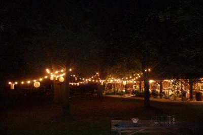 Salle de bain mansardée avec douche en briques de verre, vasques en verre, meubles en bois et fenêtre de toit.