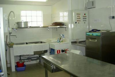 Salle de bain mansardée avec douche en briques de verre, vasques en verre, meubles en bois et fenêtre de toit.