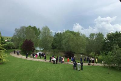 Salle de bain mansardée avec douche en briques de verre, vasques en verre, meubles en bois et fenêtre de toit.