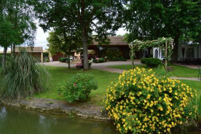 Salle de bain mansardée avec douche en briques de verre, vasques en verre, meubles en bois et fenêtre de toit.