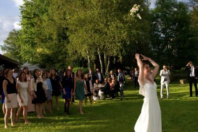 Salle de bain mansardée avec douche en briques de verre, vasques en verre, meubles en bois et fenêtre de toit.