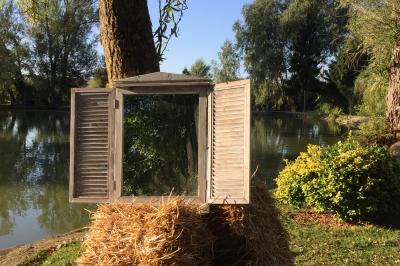 Salle de bain mansardée avec douche en briques de verre, vasques en verre, meubles en bois et fenêtre de toit.