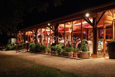 Salle de bain mansardée avec douche en briques de verre, vasques en verre, meubles en bois et fenêtre de toit.