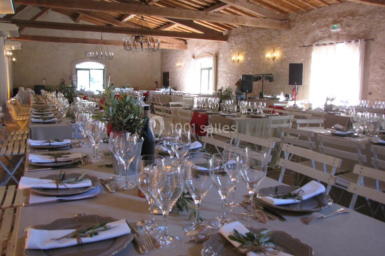 Location salle Pomérols (Hérault) - Domaine Fon de Rey #28 Salle de réception décorée avec des tables dressées, nappes beige, vaisselle élégante et branches d'olivier.