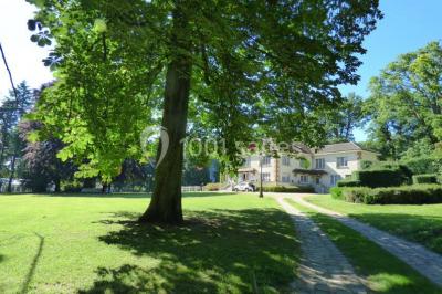 Salle de bain moderne avec douche à l'italienne, barres d'appui, toilettes et carrelage gris foncé.