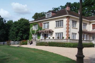 Salle de bain moderne avec douche à l'italienne, barres d'appui, toilettes et carrelage gris foncé.
