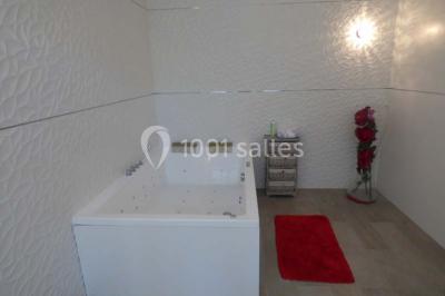 Salle de bain moderne avec douche à l'italienne, barres d'appui, toilettes et carrelage gris foncé.