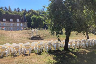 Salon rustique avec murs en pierre, canapés en cuir, table basse et porte ouverte donnant sur un jardin ensoleillé.