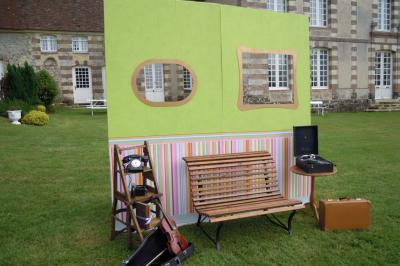 Salon rustique avec murs en pierre, canapés en cuir, table basse et porte ouverte donnant sur un jardin ensoleillé.