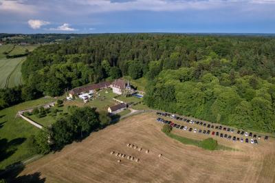 Salon rustique avec murs en pierre, canapés en cuir, table basse et porte ouverte donnant sur un jardin ensoleillé.