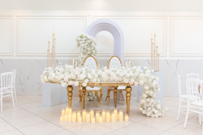Un groupe de serveurs et serveuses en uniforme posant dans une salle de réception élégante.