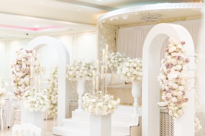 Un groupe de serveurs et serveuses en uniforme posant dans une salle de réception élégante.