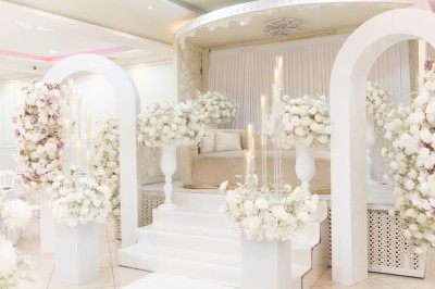 Un groupe de serveurs et serveuses en uniforme posant dans une salle de réception élégante.