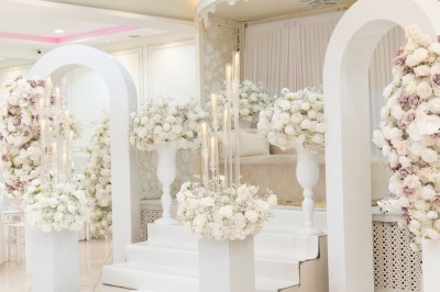 Un groupe de serveurs et serveuses en uniforme posant dans une salle de réception élégante.