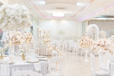 Un groupe de serveurs et serveuses en uniforme posant dans une salle de réception élégante.