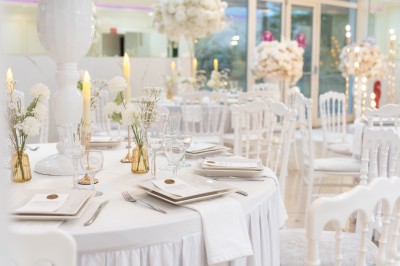 Un groupe de serveurs et serveuses en uniforme posant dans une salle de réception élégante.