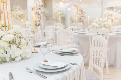 Un groupe de serveurs et serveuses en uniforme posant dans une salle de réception élégante.