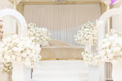 Un groupe de serveurs et serveuses en uniforme posant dans une salle de réception élégante.