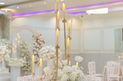 Un groupe de serveurs et serveuses en uniforme posant dans une salle de réception élégante.