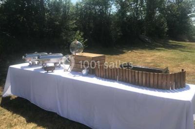 Plateau doré avec verrines et brochettes apéritives, disposé sur une table décorée pour un événement.
