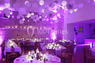 Intérieur d'un chalet en bois avec table, chaises recouvertes de fourrure, poêle allumé et vase de fleurs sur une table…