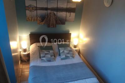 Intérieur d'un chalet en bois avec table, chaises recouvertes de fourrure, poêle allumé et vase de fleurs sur une table…