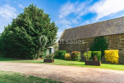Intérieur d'un chalet en bois avec table, chaises recouvertes de fourrure, poêle allumé et vase de fleurs sur une table…