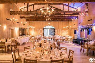 Des invités assis en plein air applaudissent lors d'une cérémonie sous des arbres aux feuilles partiellement jaunies.
