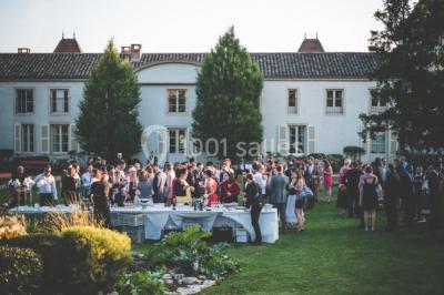Des invités assis en plein air applaudissent lors d'une cérémonie sous des arbres aux feuilles partiellement jaunies.