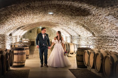 Des invités assis en plein air applaudissent lors d'une cérémonie sous des arbres aux feuilles partiellement jaunies.
