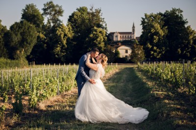 Des invités assis en plein air applaudissent lors d'une cérémonie sous des arbres aux feuilles partiellement jaunies.