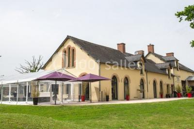 Bouteilles d'eau, tasses empilées et bocal de biscuits disposés sur une table en bois.
