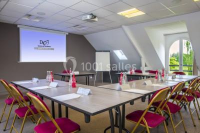 Bouteilles d'eau, tasses empilées et bocal de biscuits disposés sur une table en bois.