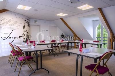 Bouteilles d'eau, tasses empilées et bocal de biscuits disposés sur une table en bois.
