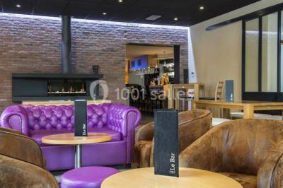 Bouteilles d'eau, tasses empilées et bocal de biscuits disposés sur une table en bois.