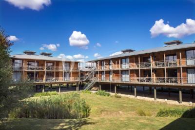 Bouteilles d'eau, tasses empilées et bocal de biscuits disposés sur une table en bois.