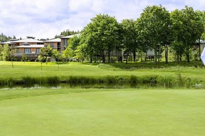 Bouteilles d'eau, tasses empilées et bocal de biscuits disposés sur une table en bois.