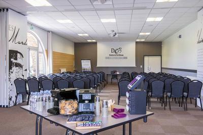 Bouteilles d'eau, tasses empilées et bocal de biscuits disposés sur une table en bois.