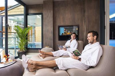 Bouteilles d'eau, tasses empilées et bocal de biscuits disposés sur une table en bois.