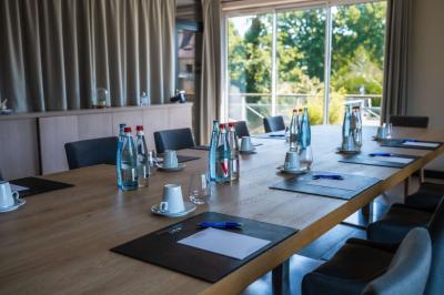 Bouteilles d'eau, tasses empilées et bocal de biscuits disposés sur une table en bois.