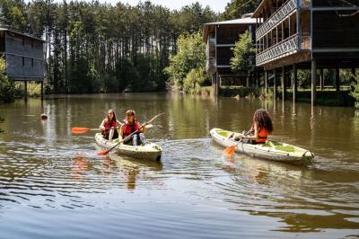 Bouteilles d'eau, tasses empilées et bocal de biscuits disposés sur une table en bois.