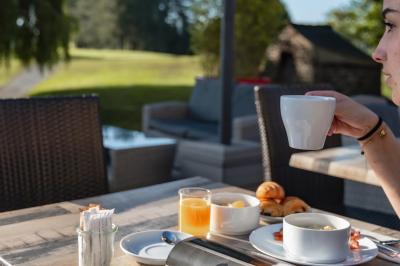 Bouteilles d'eau, tasses empilées et bocal de biscuits disposés sur une table en bois.