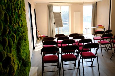 Bouteilles d'eau, tasses empilées et bocal de biscuits disposés sur une table en bois.