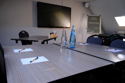 Bouteilles d'eau, tasses empilées et bocal de biscuits disposés sur une table en bois.