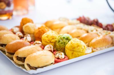 Grande maison en pierre entourée de verdure, avec une cour ensoleillée et des arbres en arrière-plan.