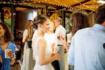Grande maison en pierre entourée de verdure, avec une cour ensoleillée et des arbres en arrière-plan.
